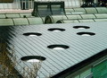Covering of a flat roof with vitreous enamel coated steel panels